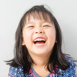 a young child smiling and laughing after a great dental checkup