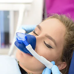A patient at ease receiving dental sedation as part of her regular visit.